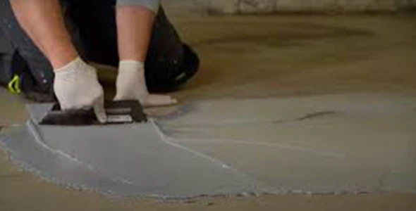 Worker smoothing out epoxy floor in Denver, Colorado.