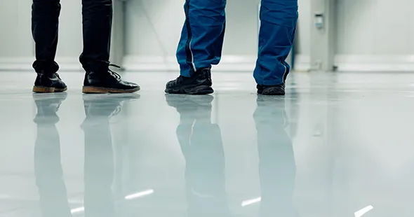 Workers in protective gear standing on newly installed epoxy floor in Morgantown, West Virginia.